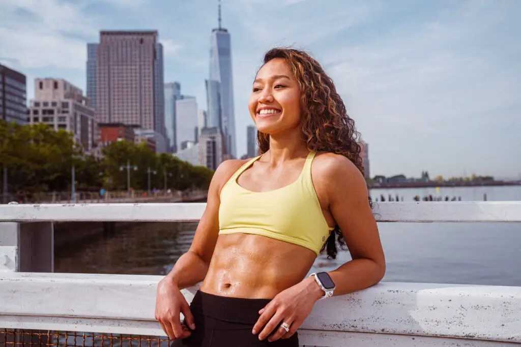 woman smiles in fitness equipment with abdominal muscles