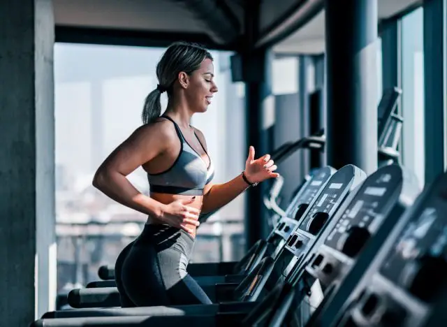 woman doing sprint on treadmill in gym, belly fat exercises concept