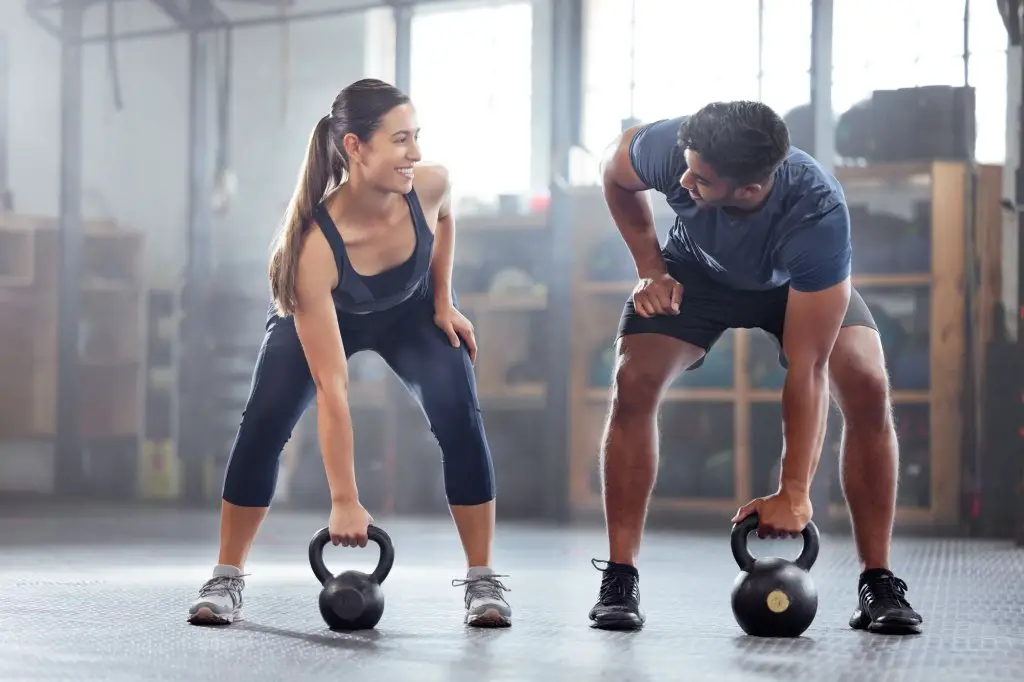 Man and woman with kettlebells.