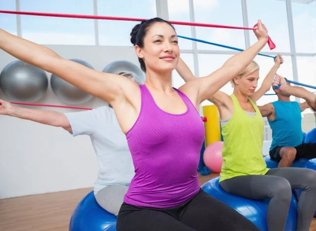 woman working out with resistance band in workout class